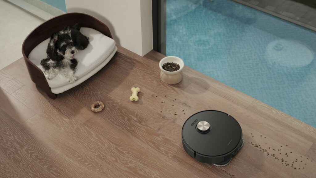 Hond op stoel terwijl robotstofzuiger vuil op houten vloer bij houten wanden opruimt