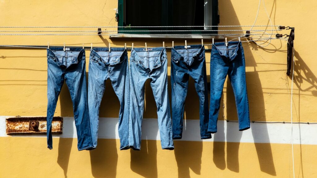 Jeans hangend aan waslijn buiten na reinigen van vlekken uit denim