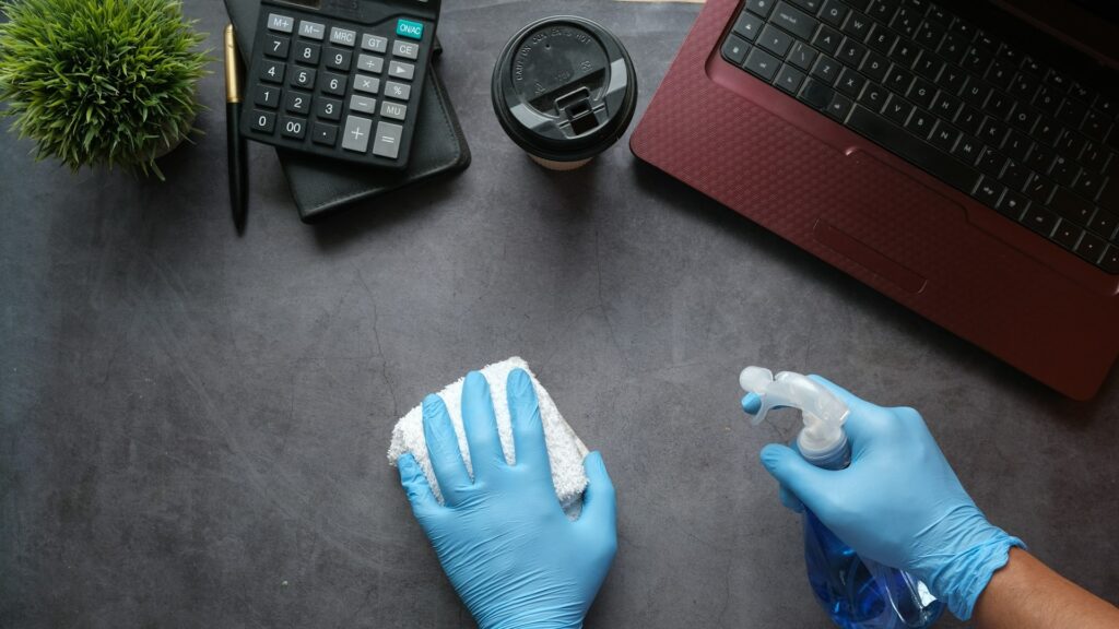Bureau reinigen met spray en doek bij veelgebruikte oppervlakken schoonmaken