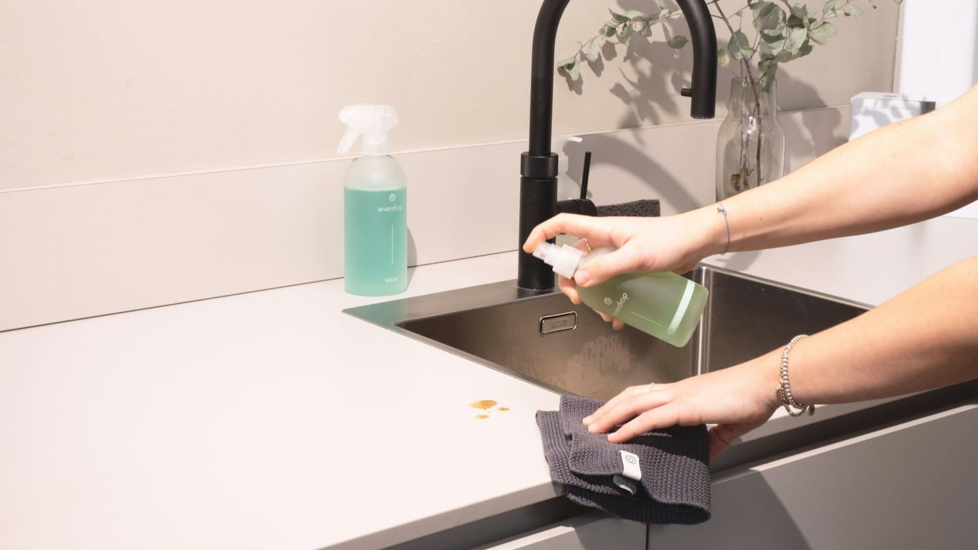 Keukenblad wordt schoongemaakt met reiniger, risico op schade door schoonmaakfouten