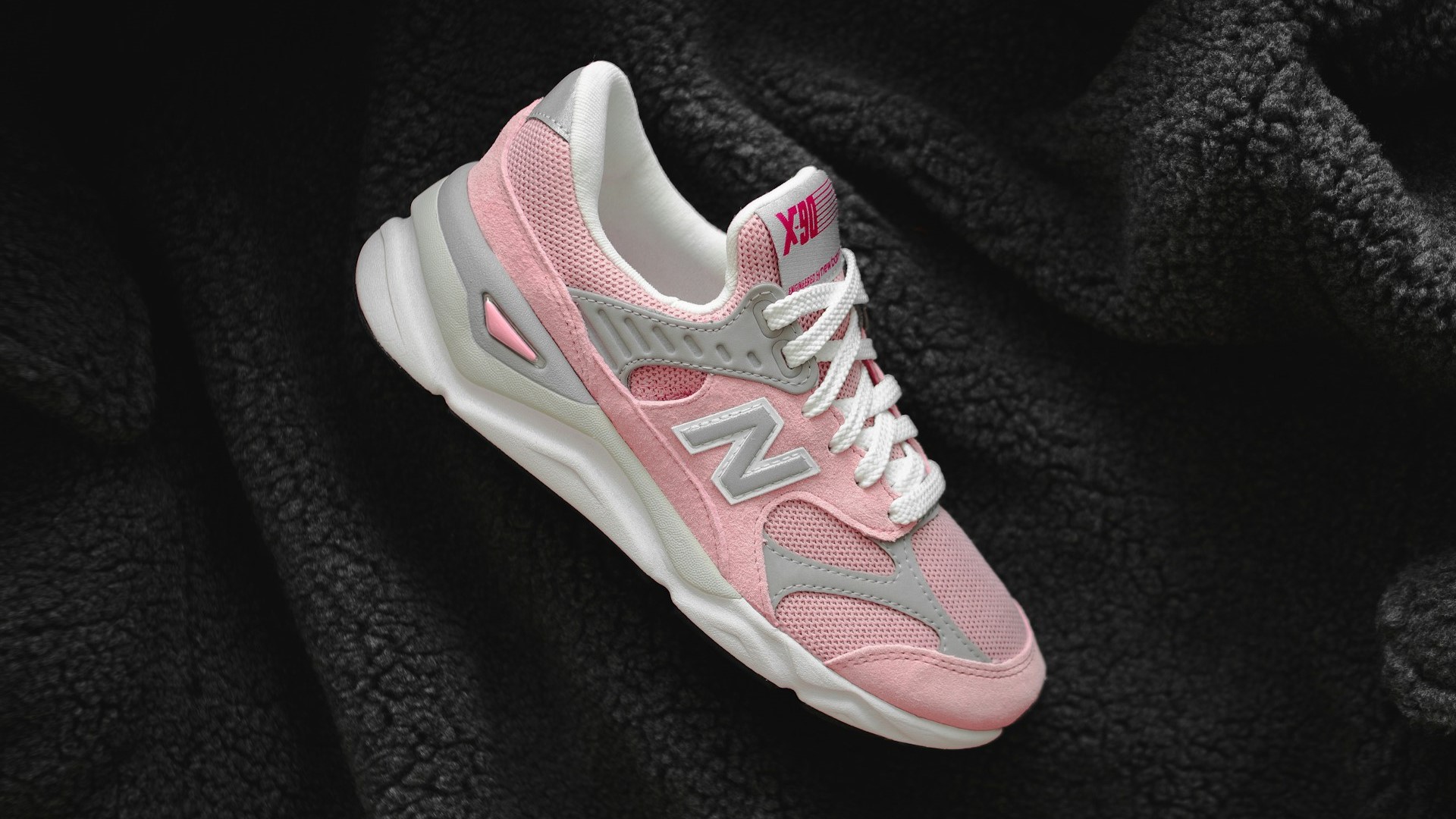 Roze en grijze sneaker van suède en mesh op zwarte fleece ondergrond, perfect voorbeeld voor sneakers schoonmaken