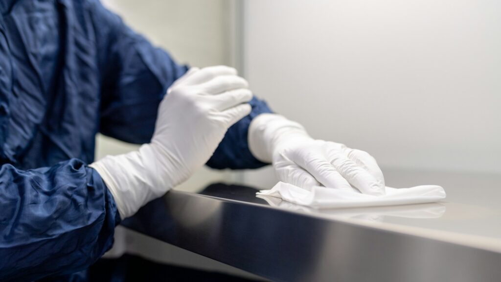 Veelgebruikte oppervlakken schoonmaken met doek en handschoenen op een werkblad