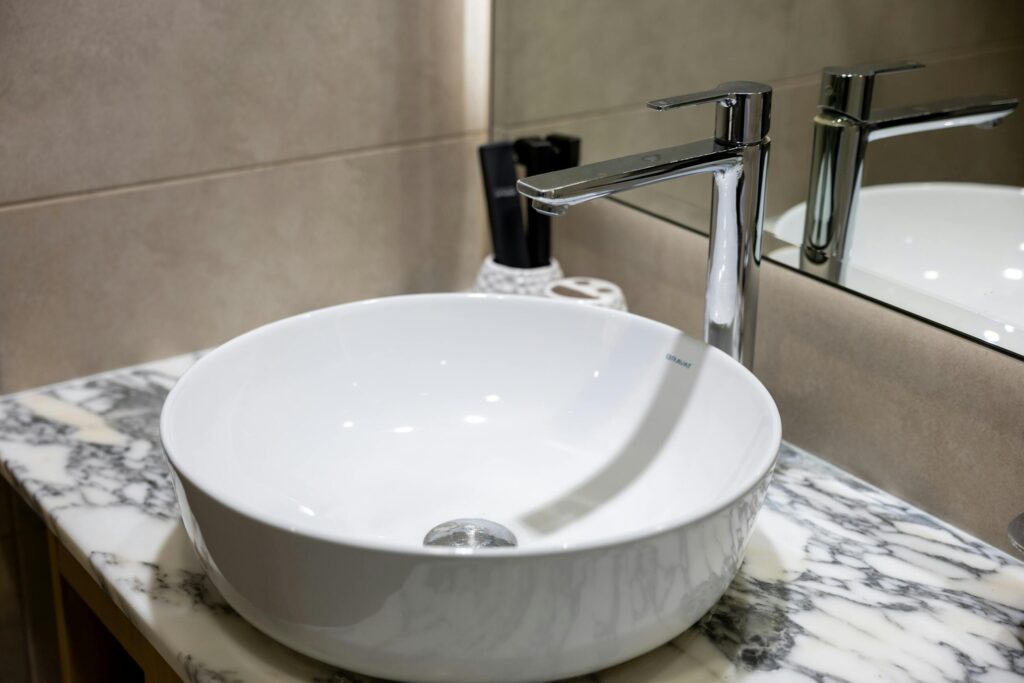 Moderne wastafel met kraan op marmeren blad in badkamer