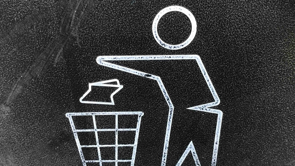 Pictogram van een persoon die afval in een prullenbak gooit, symbool voor afvalscheiding.